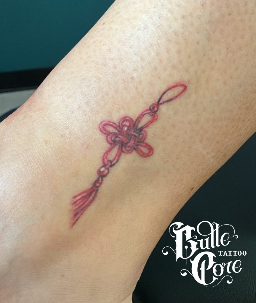 Tatouage noeud chinois rouge micro réalisme fineline
